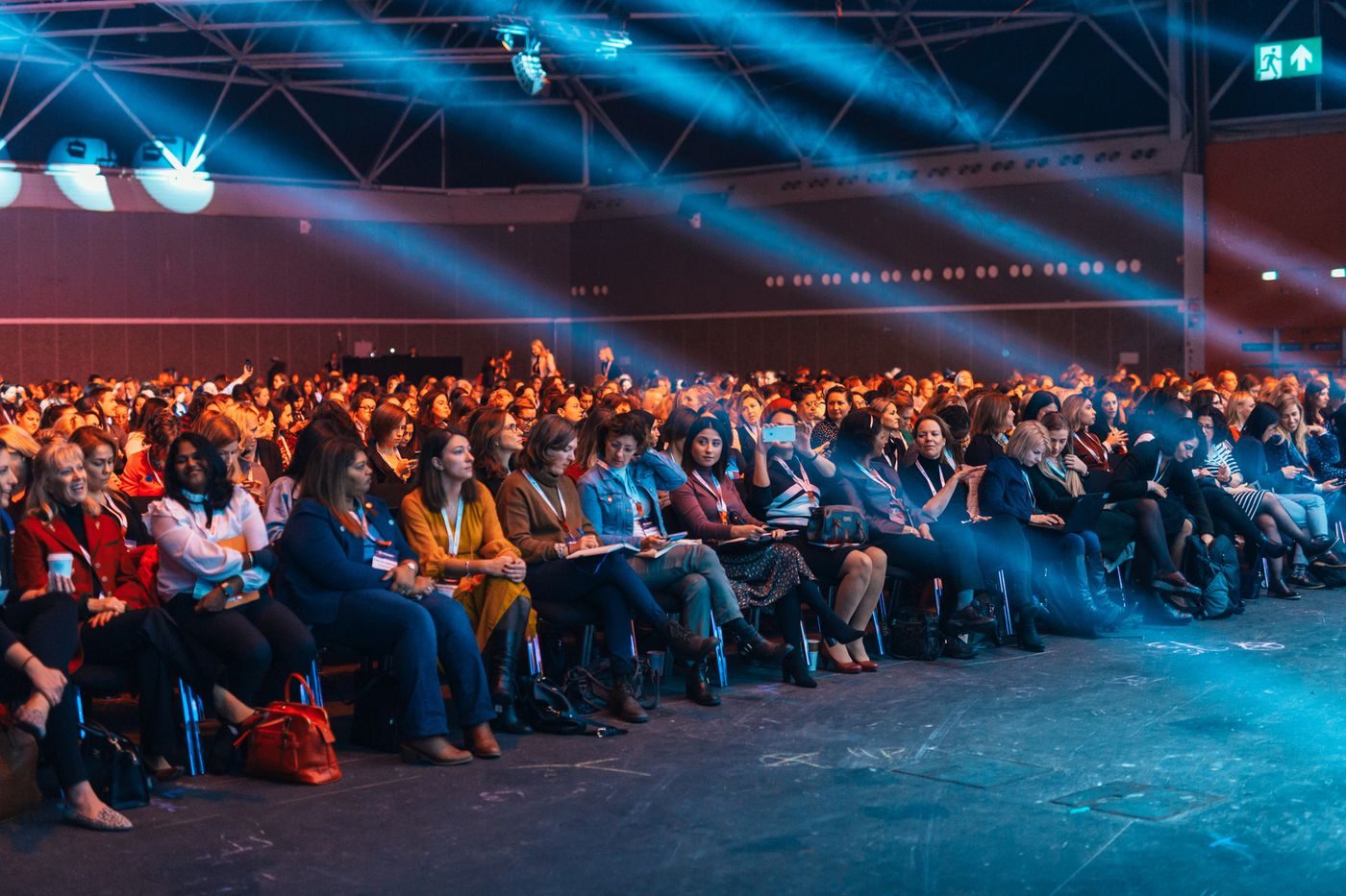 A full auditorium facing a lit stage