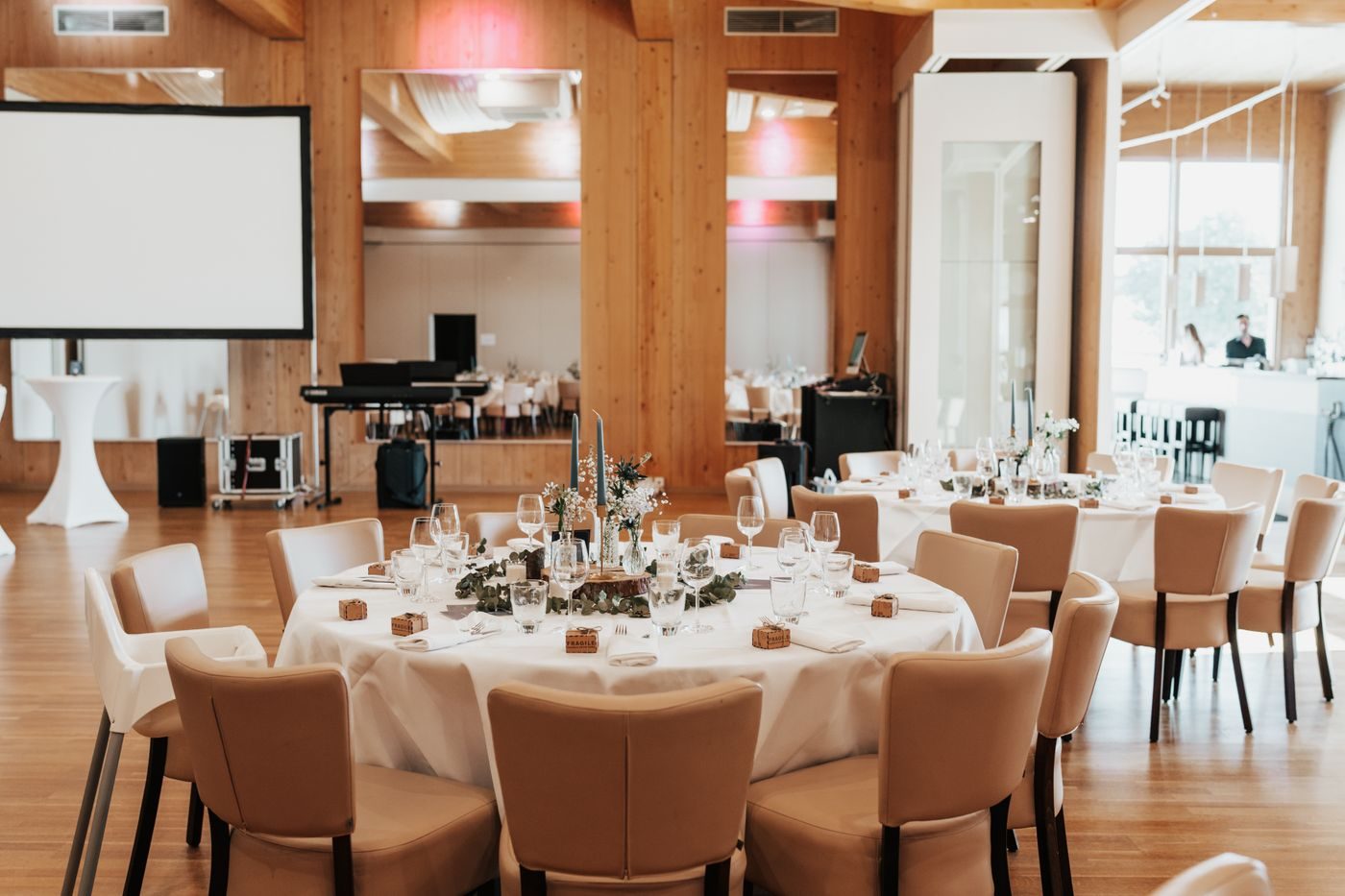 Round tables set for a reception in a bright hall